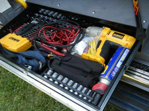 1988 Ford E350 - Toolbox drawer contains an impact wrench, sockets, pliers, and a can of lubricant.