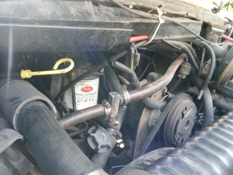 1988 Ford E350 - Close-up view of the engine bay in a 1988 Ford E350, showing the oil filter and drive belts.