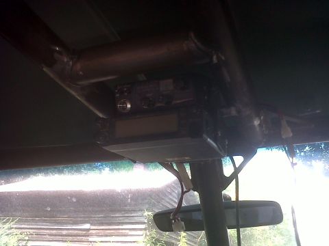 1990 Ford Bronco - CB radio mounted on a roll cage, with a rearview mirror visible below.