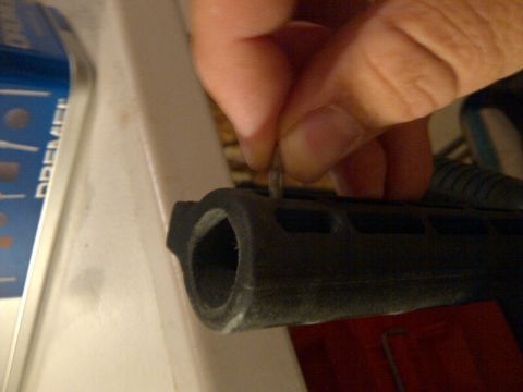 1989 Ford Bronco - A hand is shown inserting a pin into a black part, with a Dremel tool box in the background.