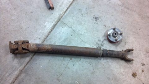 1995 Jeep Cherokee - A rusty driveshaft and a hub assembly are shown lying on a concrete surface.
