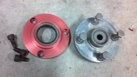 1995 Jeep Cherokee - Two automotive wheel hubs, one red and one silver, are shown with several bolts on a concrete surface.