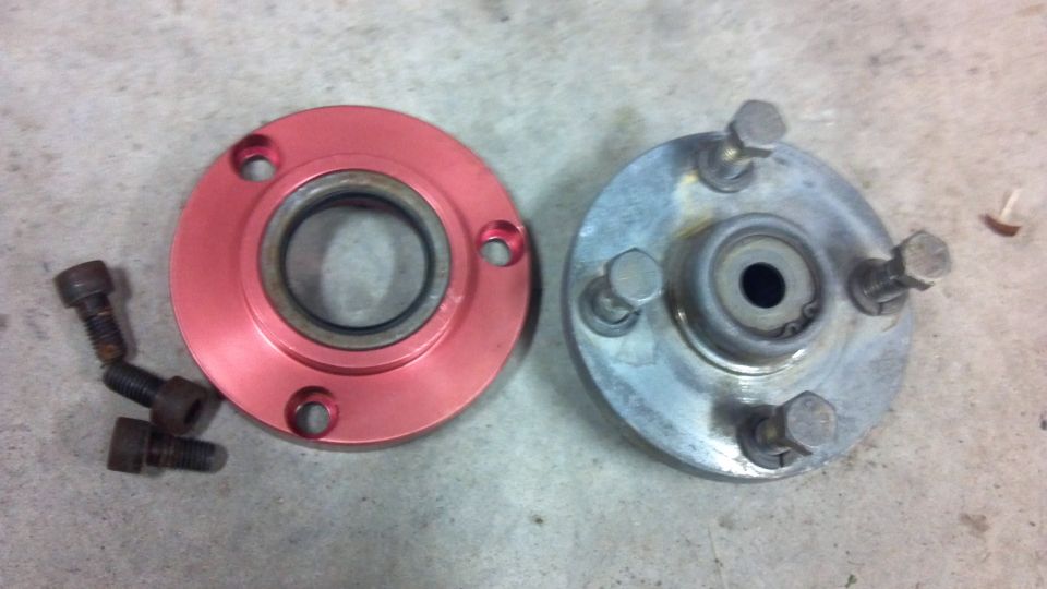 two automotive wheel hubs, one red and one silver, with bolts
