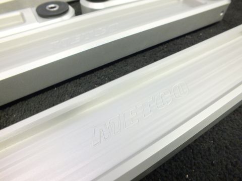 2003 Ford Crown Victoria - Angled view of machined aluminum control arms showing the engraved METCO logo.
