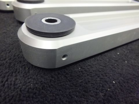 2003 Ford Crown Victoria - Detail of a machined aluminum control arm showing the bushing eye and a tapped hole.