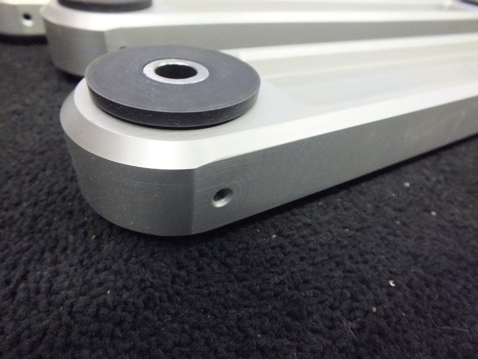 Close-up of a billet aluminum suspension arm end with bushing and mounting hole