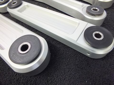 2003 Ford Crown Victoria - Closeup of pressed rubber bushings in machined aluminum suspension arm eyes.