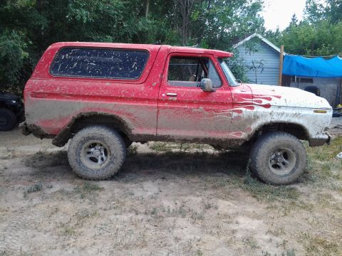 1979 Ford Bronco - Side view of a mud-splattered Ford Bronco, likely from the late 1970s.