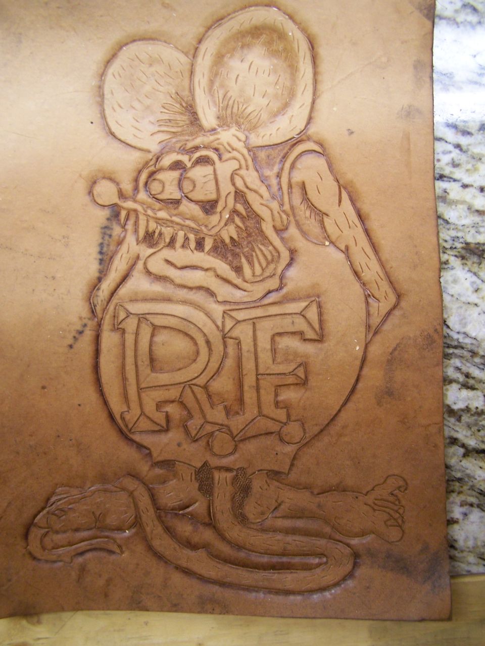 Leather carving of a rat with R.I.F. text