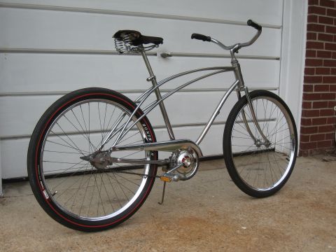 1994 Ford Bronco - This chrome bicycle with red-striped tires is parked in front of a garage door.