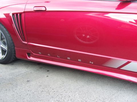 2007 Ford Mustang - Close-up of a red Saleen Mustang's side, highlighting the distinctive rocker panel lettering and body kit.