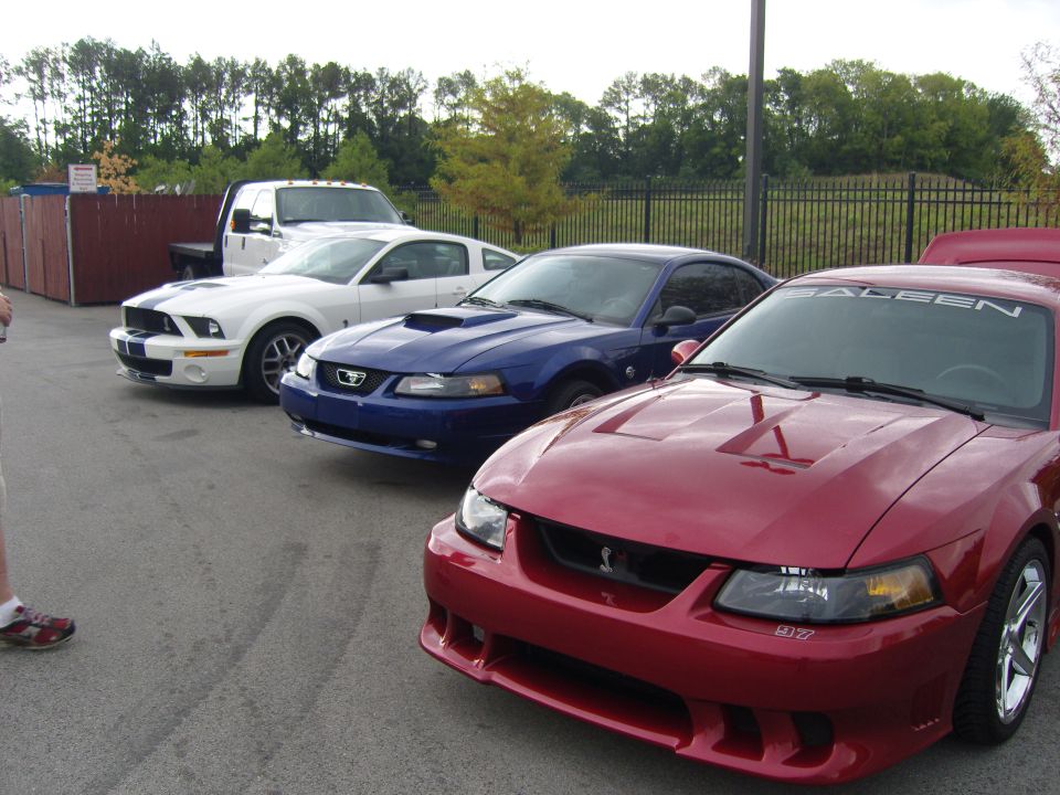 Red Saleen Mustang with hood scoops and a white stripe on the windshield