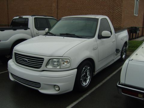 2007 Ford Mustang - White 2000 Ford F-150 SVT Lightning pickup truck in a parking lot.