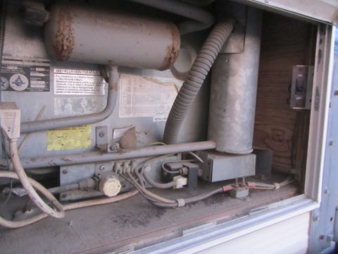 1968 Ford Mustang - Close-up of RV refrigerator components, showing wiring, gas line, and a control knob.