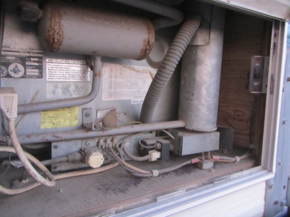 RV refrigerator components with wiring, gas line, and control knob