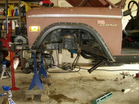 1995 Ford Bronco - Ford Bronco body and suspension components are visible while the vehicle is supported by jack stands.