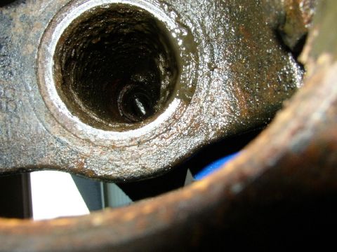 1995 Ford Bronco - Close-up view of a heavily greased and corroded metal component, showing its hollow, textured interior.