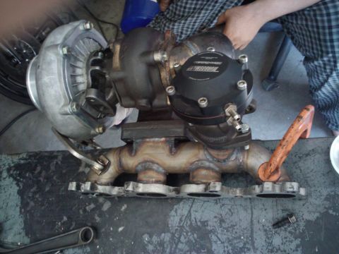 1995 Ford Probe - Turbocharger and exhaust manifold assembly with a black wastegate actuator.