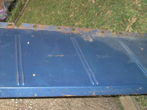 1971 Ford Bronco - A close-up view of a blue metal panel, showing signs of rust and wear.