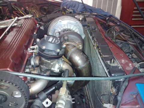 1995 Ford Probe - Close-up view of a modified engine bay a turbocharger and associated plumbing.