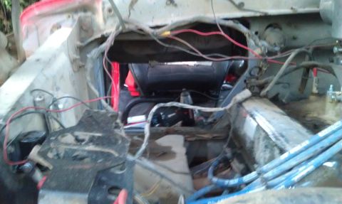 1978 Ford Bronco - The engine bay of a vehicle is shown with wiring and various components visible.