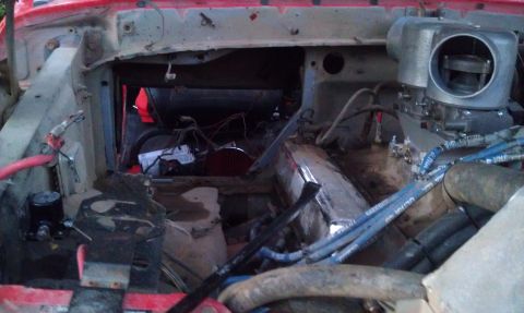 1978 Ford Bronco - The engine bay shows a red exterior and a complex setup with a large carburetor and exposed wiring.