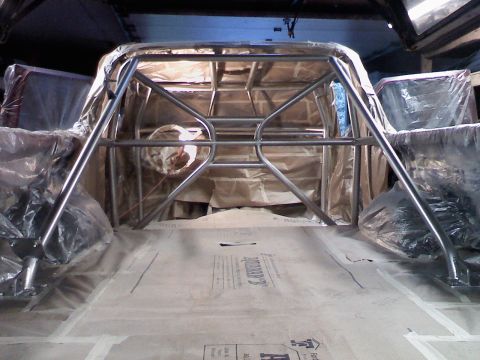 1989 Ford Bronco - Interior view of a vehicle with a newly installed roll cage, covered for protection.