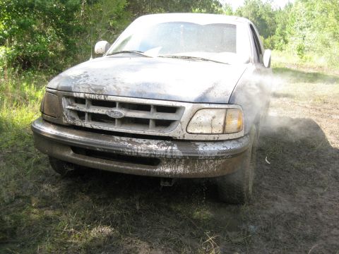 1994 Ford Bronco - This 1997 Ford F-150 is covered in mud as it drives through a muddy area.