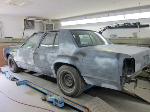 1991 Ford LTD Crown Victoria - This sedan, likely a Ford Crown Victoria, is in a garage being prepped for paint, with its rear bumper removed.