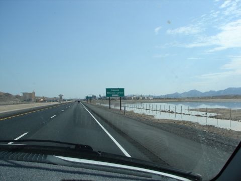 1992 Ford Taurus - Driving on a highway towards the Nevada Welcome Center with a body of water to the right.