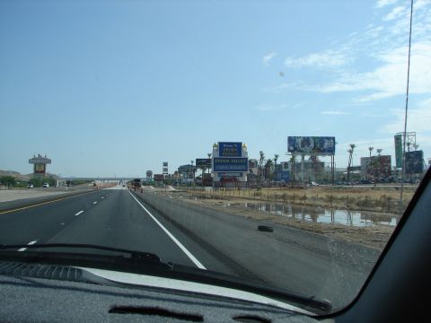 1992 Ford Taurus - Approaching Primm Valley Casino Resorts on a sunny day with several billboards lining the highway.