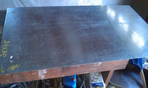 1978 Ford Bronco - Sheet metal marked 28x48 and 6 GAL rests on a workbench, likely for a project.