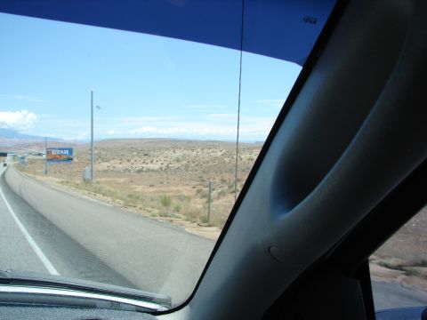1992 Ford Taurus - View from inside a vehicle traveling on a highway through a desert landscape.