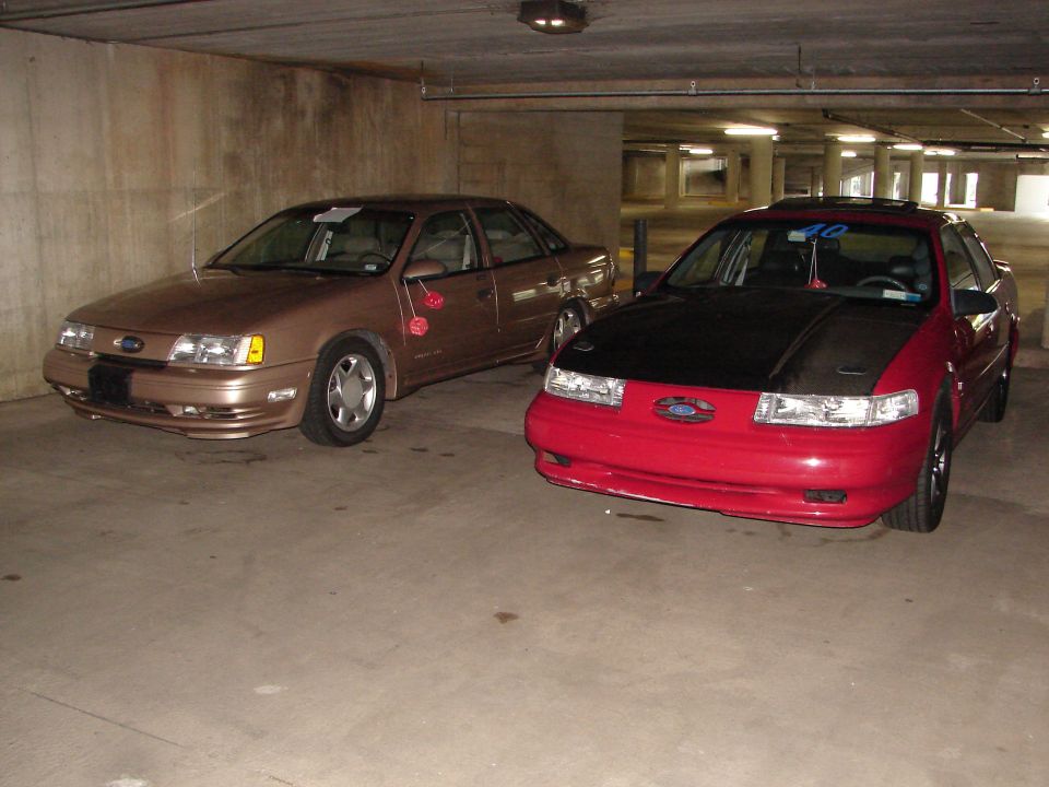 1992 Ford Taurus sedans, red with black hood and tan, parked in garage