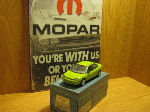 2010 Mitsubishi Outlander - A toy Dodge Neon sits on its box, displayed in front of a vintage Mopar advertisement.