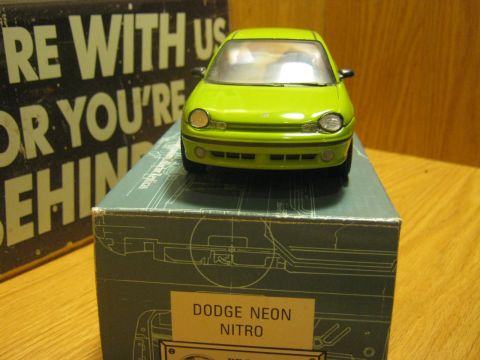 2010 Mitsubishi Outlander - A green toy Dodge Neon Nitro is displayed on its packaging, which features diagrams and text.