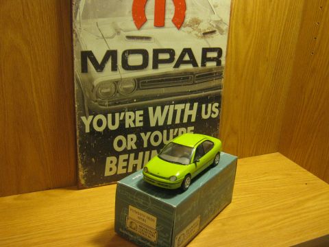 2010 Mitsubishi Outlander - A toy car sits on a box in front of a Mopar advertisement.