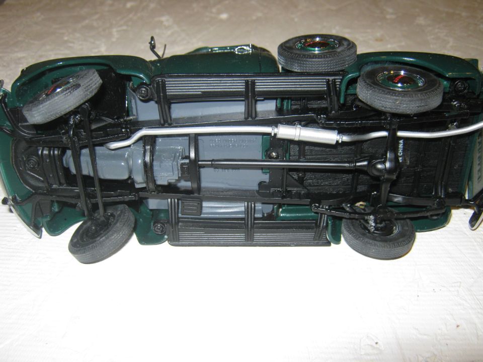 Underside view of a green model car, showing suspension and exhaust