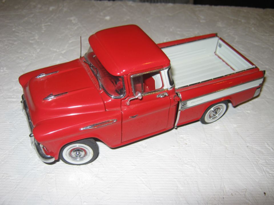 red pickup truck model with white bed interior and chrome trim