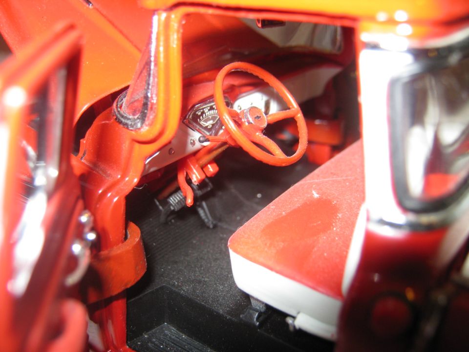 Model car interior showing dashboard, steering wheel, and seat
