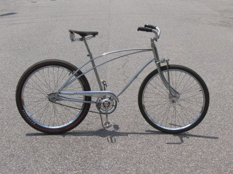 1994 Ford Bronco - Cruiser bicycle with chrome frame and red-striped tires parked on asphalt.