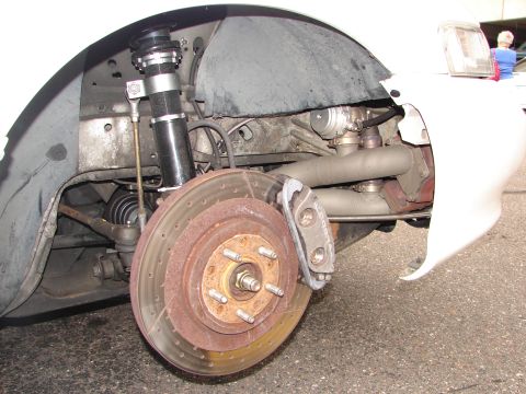 1992 Ford Taurus - Close-up view of the front wheel assembly, showing the brake system and suspension details of a car.