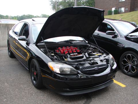 1992 Ford Taurus - Black Ford Taurus with hood open, revealing its engine and red intake manifold.