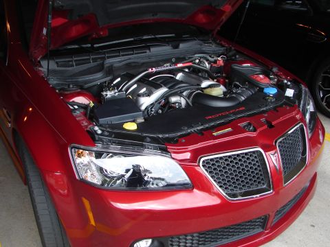 1992 Ford Taurus - Engine bay of a red car, a V8 engine and aftermarket intake system.