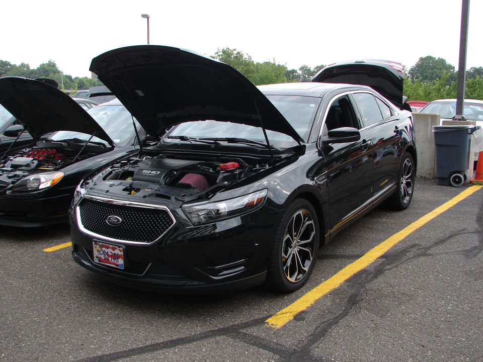 Black sedan with hood open, showing SHO engine. 2013 model