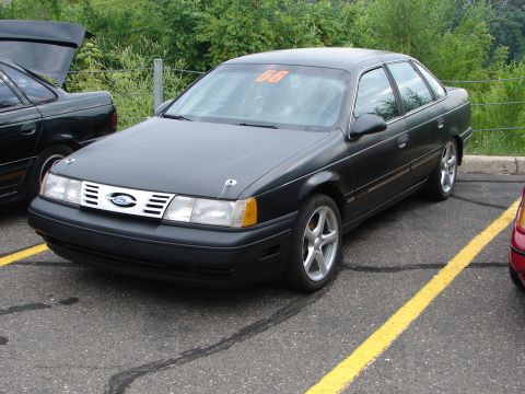 1992 Ford Taurus - Front view of a 1992 Ford Taurus sedan, parked outdoors with another vehicle nearby.