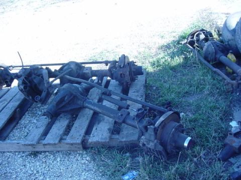 1992 Ford Bronco - Multiple vehicle axles are laid out on pallets and the ground.