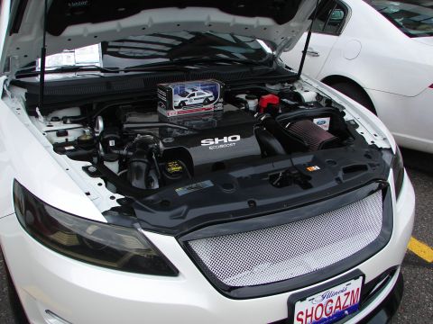 1992 Ford Taurus - The engine bay of a white Ford Taurus SHO, an EcoBoost engine and a toy police car.