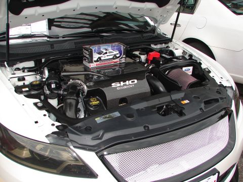 1992 Ford Taurus - The engine bay of a white Ford Taurus SHO, a "SHO ECOBOOST" engine cover and a toy police car.