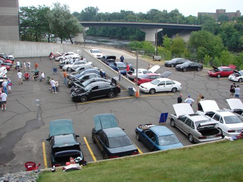 1992 Ford Taurus - A gathering of vehicles, including a 1992 Ford Taurus, with many hoods open at a car show event.